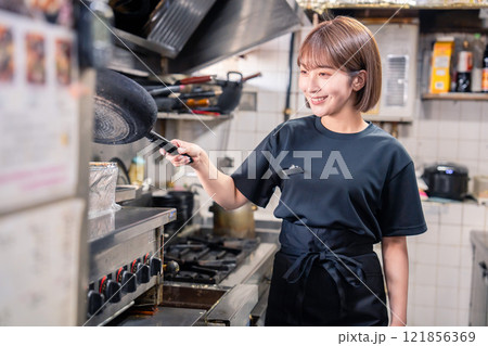 居酒屋の厨房で働くキッチンスタッフの女性 居酒屋の厨房で働くキッチンスタッフの女性 121856369