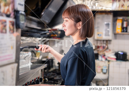 居酒屋の厨房で働くキッチンスタッフの女性 居酒屋の厨房で働くキッチンスタッフの女性 121856370