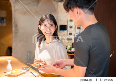 焼き鳥屋さんの女性客と店員 121856500