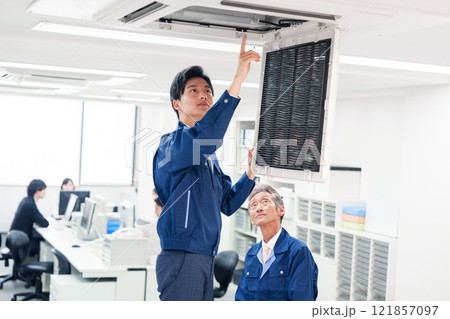 ビルのエアコンの点検をする作業服の男性 ビルのエアコンの点検をする作業服の男性 121857097
