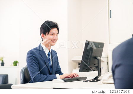 オフィスでデスクワークをする若い男性 121857168