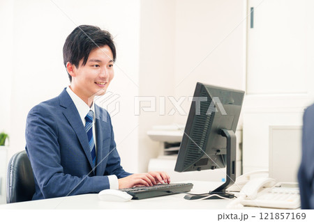 オフィスでデスクワークをする若い男性 121857169