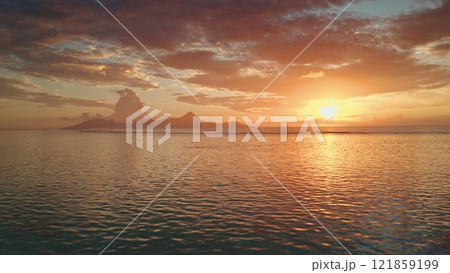 Drone fly over sunset sand beach on Tahiti tropical island. Bright orange evening sky reflects on calm ocean water waves. Beautiful sunrise landscape. Remote wild nature paradise, exotic summer travel Drone fly over sunset sand beach on Tahiti tropical island. Bright orange evening sky reflects on calm ocean water waves. Beautiful sunrise landscape. Remote wild nature paradise, exotic summer travel 121859199