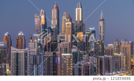 Dubai marina with traffic on sheikh zayed road panorama day to night timelapse lights turn on. Dubai marina with traffic on sheikh zayed road panorama day to night timelapse lights turn on. 121859898