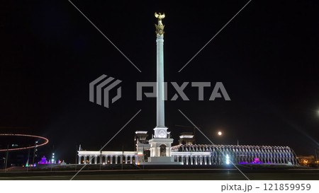 Stele monument Kazakh Eli with bird Samruk and Palace of Independence timelapse hyperlapse at night. 121859959