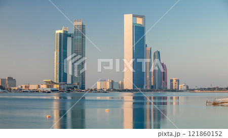 Abu Dhabi city skyline with skyscrapers after sunrise with water reflection timelapse 121860152
