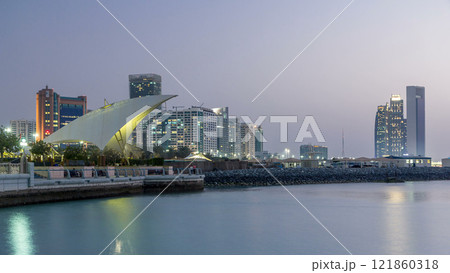 Promenade in Abu Dhabi illuminated at dusk, day to night timelapse. 121860318