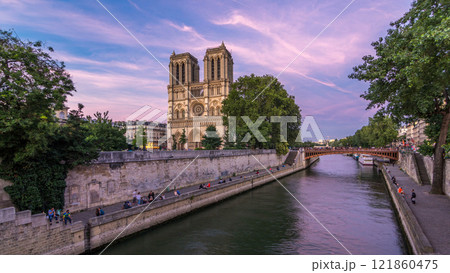 Front view of Notre Dame De Paris cathedral day to night timelapse after sunset. 121860475
