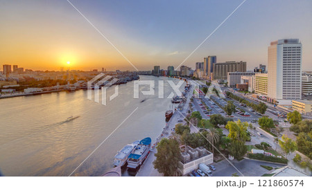 Dubai creek landscape at sunset timelapse with boats and ship near waterfront Dubai creek landscape at sunset timelapse with boats and ship near waterfront 121860574