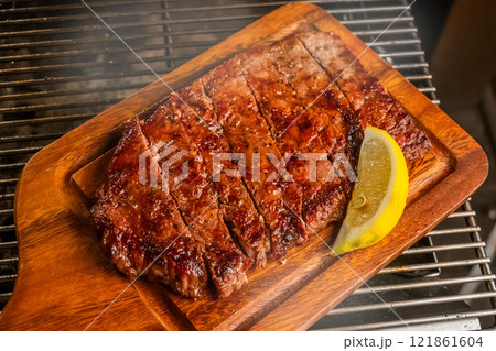 ワイルドに焼くステーキ Grill a steak over an outdoor ワイルドに焼くステーキ Grill a steak over an outdoor 121861604
