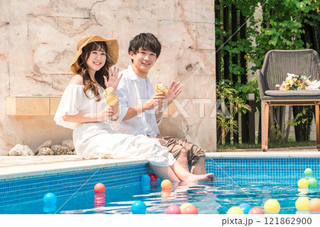 旅行先のリゾートホテルのプールサイドで遊ぶカップル・夫婦 121862900