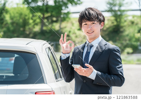 車の査定をするカーディーラの査定士・営業マンの若いアジア人男性 車の査定をするカーディーラの査定士・営業マンの若いアジア人男性 121863588