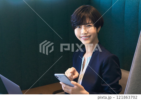オフィスのブースでテレワークするスーツのビジネスウーマン撮影協力:LINK FOREST オフィスのブースでテレワークするスーツのビジネスウーマン撮影協力:LINK FOREST 121863702
