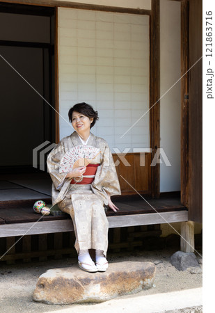 縁側に座って扇子で涼んでいる着物姿の女性 縁側に座って扇子で涼んでいる着物姿の女性 121863716