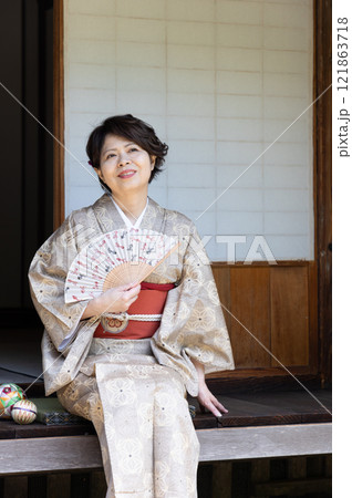 縁側に座って扇子で涼んでいる着物姿の女性 縁側に座って扇子で涼んでいる着物姿の女性 121863718