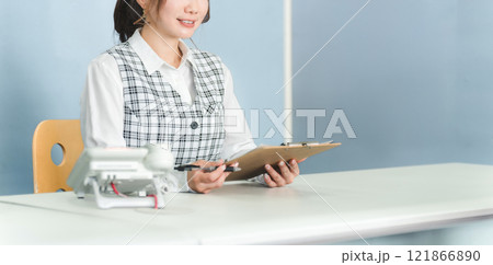 カウンターに座り接客する事務員の女性（受付・窓口・フロント） 121866890