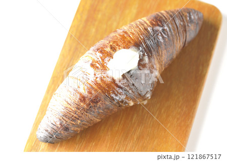 カッティングボードに乗ったちょっと焦げてる黒ワッサンを白背景で撮影 121867517