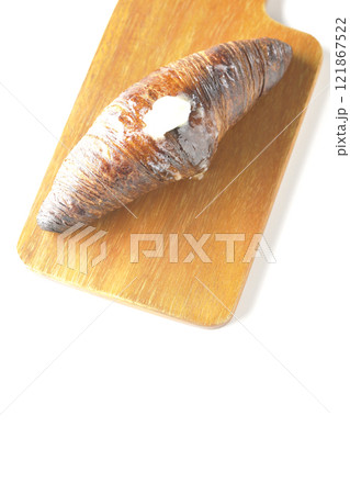 カッティングボードに乗ったちょっと焦げてる黒ワッサンを白背景で撮影 121867522