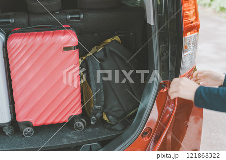 車ににスーツケースを積む女性 121868322