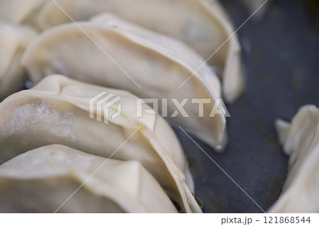 フライパンで焼かれている冷凍餃子 (写真素材) フライパンで焼かれている冷凍餃子 (写真素材) 121868544