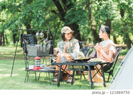 公園・キャンプ場でデイキャンプ・キャンプ・バーベキューを楽しむ仲良しのファミリー 121869750