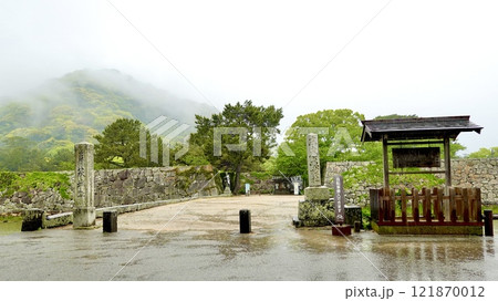 雨の萩市　霞に煙る萩城址　堀を渡る橋のたもとに由良書看板が見える風景　山口県萩市 121870012
