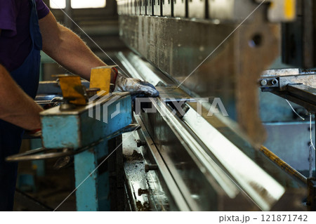Precision metalwork at a manufacturing facility during daylight hours 121871742
