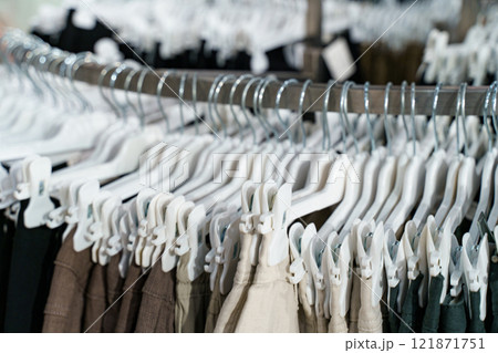 Clothing racks display a variety of stylish pants in a retail store setting 121871751