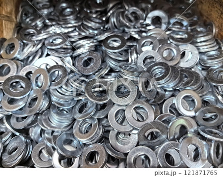 Metal washers piled together in a storage container at a workshop Metal washers piled together in a storage container at a workshop 121871765