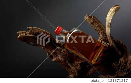 Bottle of whiskey on a old snags. 121871817