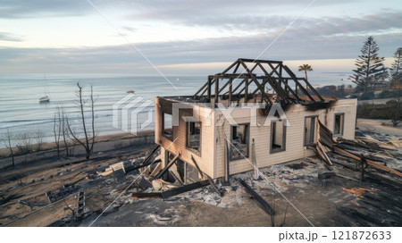 Post-Wildfire Scene of Burned Beachfront Properties and Scorched Landscape 121872633