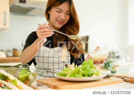A woman enjoy making salad in the kitchen A woman enjoy making salad in the kitchen 121873506