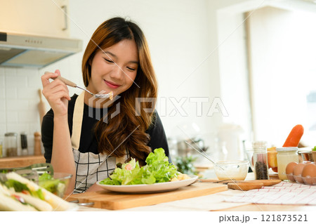 A female homecook enjoying her salad A female homecook enjoying her salad 121873521