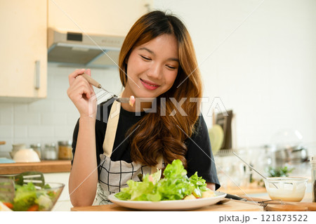 A female homecook enjoying her salad 121873522