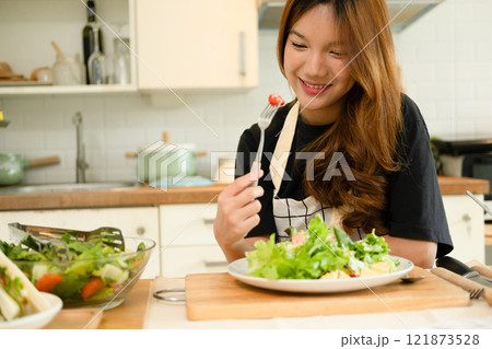 A female homecook enjoying her salad A female homecook enjoying her salad 121873528