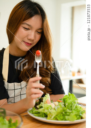 A female homecook enjoying her salad A female homecook enjoying her salad 121873533