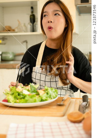 A female homecook enjoying her salad A female homecook enjoying her salad 121873546