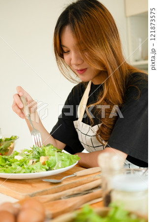 A female homecook enjoying her salad A female homecook enjoying her salad 121873575