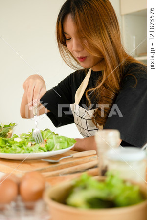 A female homecook enjoying her salad A female homecook enjoying her salad 121873576
