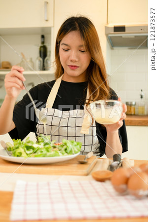 A woman enjoy making salad in the kitchen A woman enjoy making salad in the kitchen 121873577