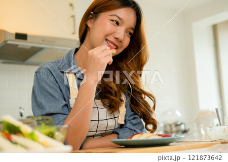 A young woman eating an apple 121873642