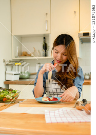 A young woman eating an apple 121873662
