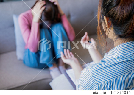 A psychiatrist counseling and consulting her patient A psychiatrist counseling and consulting her patient 121874034