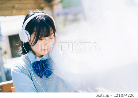 駅のホームで音楽を聴く女子高生 121874220