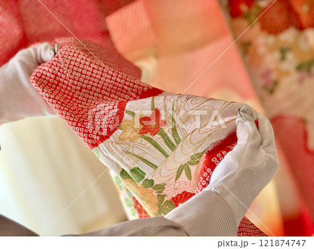 白手袋をして絞り染めの着物の柄を見る人の手元 白手袋をして絞り染めの着物の柄を見る人の手元 121874747