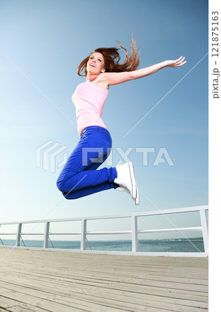 Attractive girl Young woman jumping sky 121875163