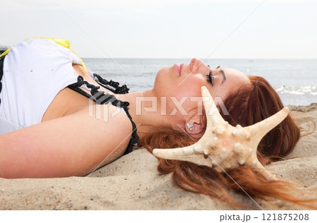 The beautiful girl lies on sea coast with shells nature vacation 121875208