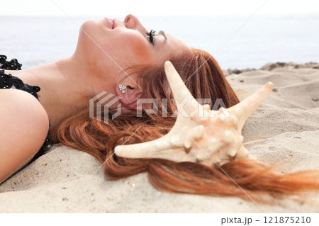 The beautiful girl lies on sea coast with shells nature vacation 121875210