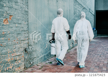Healthcare workers wearing protective hazmat suits to help prevent the spread of a toxic infection or covid pandemic. First responders cleaning a building for better hygiene and safety Healthcare workers wearing protective hazmat suits to help prevent the spread of a toxic infection or covid pandemic. First responders cleaning a building for better hygiene and safety 121875423