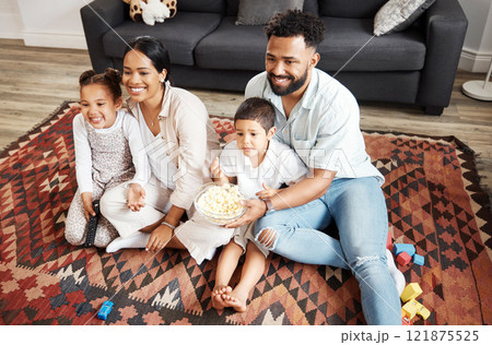 Happy, bonding family quality time at home with parents watching a movie and having snacks on the floor. Young couple being affectionate with their children and enjoying time together indoors Happy, bonding family quality time at home with parents watching a movie and having snacks on the floor. Young couple being affectionate with their children and enjoying time together indoors 121875525